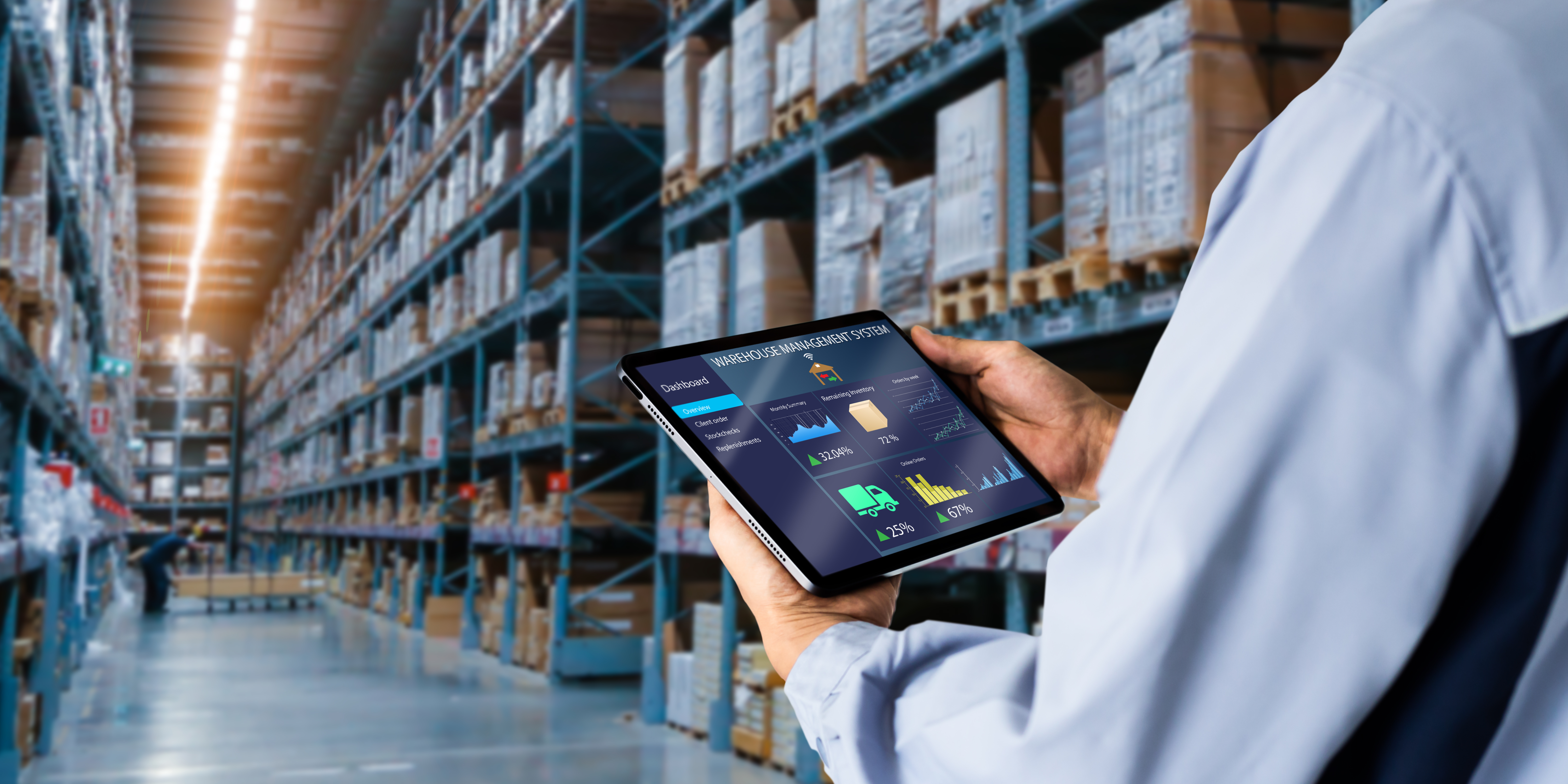 Person hält Tablet mit Lagerverwaltungssoftware in einem großen Lager mit Regalen voller Kartons